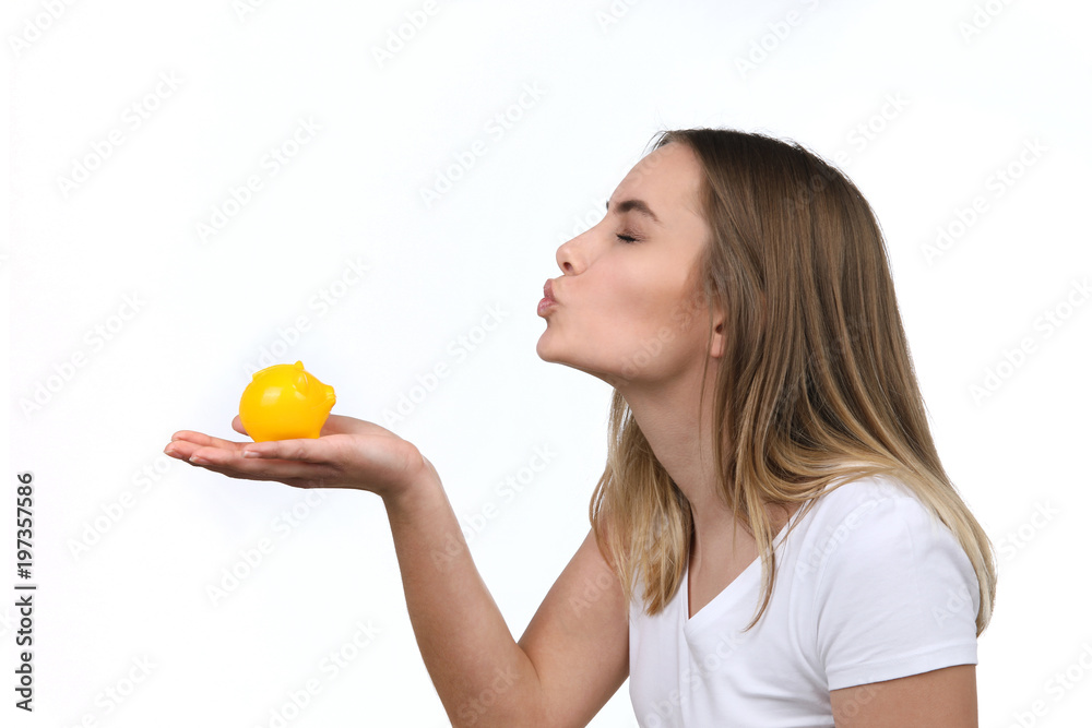 Hübsche blonde Frau küsst ein Sparschwein auf ihrer Hand Hübsche blonde Frau küsst ein Sparschwein auf ihrer Hand
