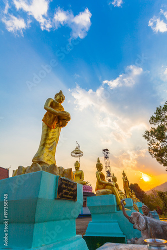 scenery sunset behind the golden buddha statue at wat Sirattanan Mongkol near Mae Kajan Hot Spring. Wiang Pa Pao Chiang Rai Thailand. photo