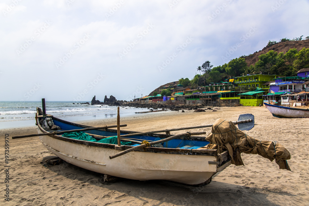 fishing boat on tropical sandy beach in sunny day