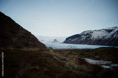 A glacier in Iceland between some mountains photo