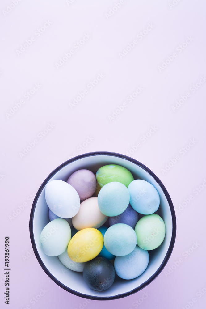 Colored eggs with pastelle tones inside a metallic bowl over a pink background, back lighted, easter concept,holiday. Colored eggs with pastelle tones inside a metallic bowl over a pink background, back lighted, easter concept,holiday.