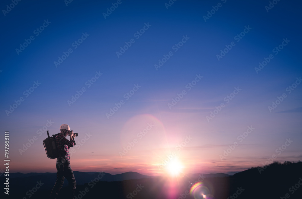 Photographe sur une montagne en train de photographier