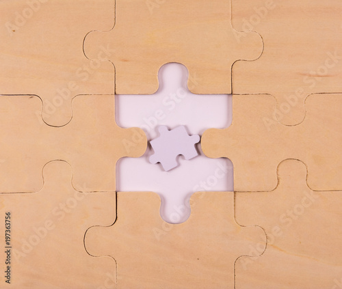 A puzzle made of wood with a too small piece in the middle that not fit in.