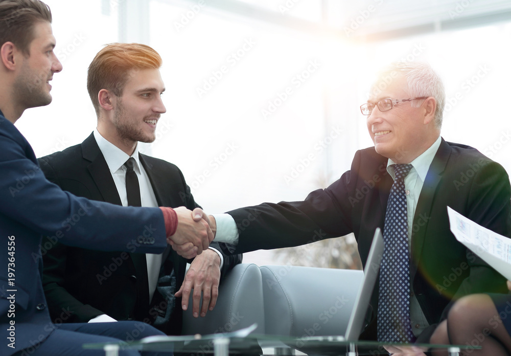 Partners concluding deal and shaking hands in the presence of te Partners concluding deal and shaking hands in the presence of te