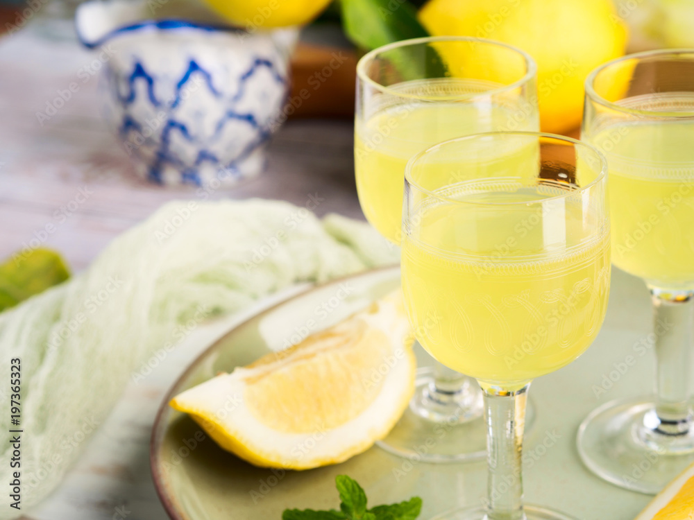 Home made limoncello served in stemmed glasses. Summer still life