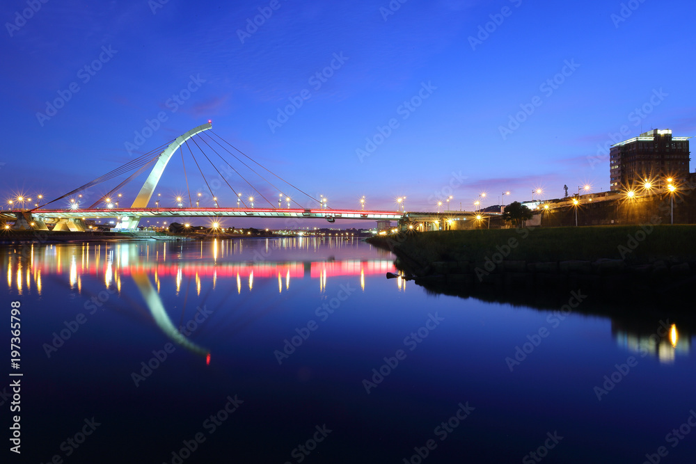 Naklejka premium The famous cable-stayed Dazhi Bridge spanning over Keelung River at dusk in Taipei City Taiwan, Asia ~ A romantic landmark bridge of Taipei with beautiful reflections on smooth water under evening sky