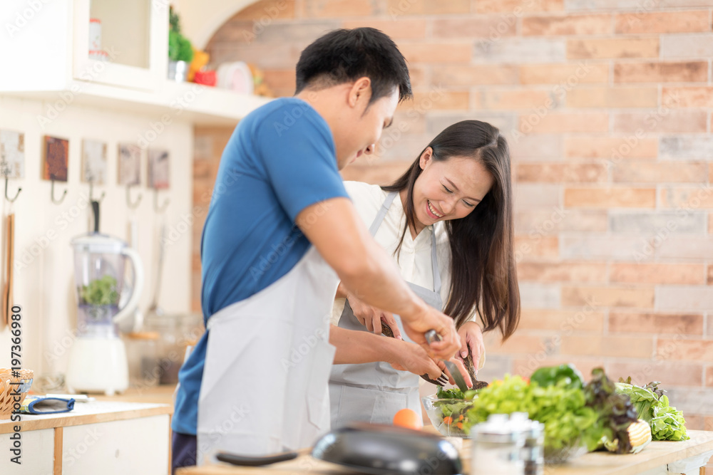 Portrait of happy young couple cooking together in the kitchen.Lover Hobby Lifestyle Concept