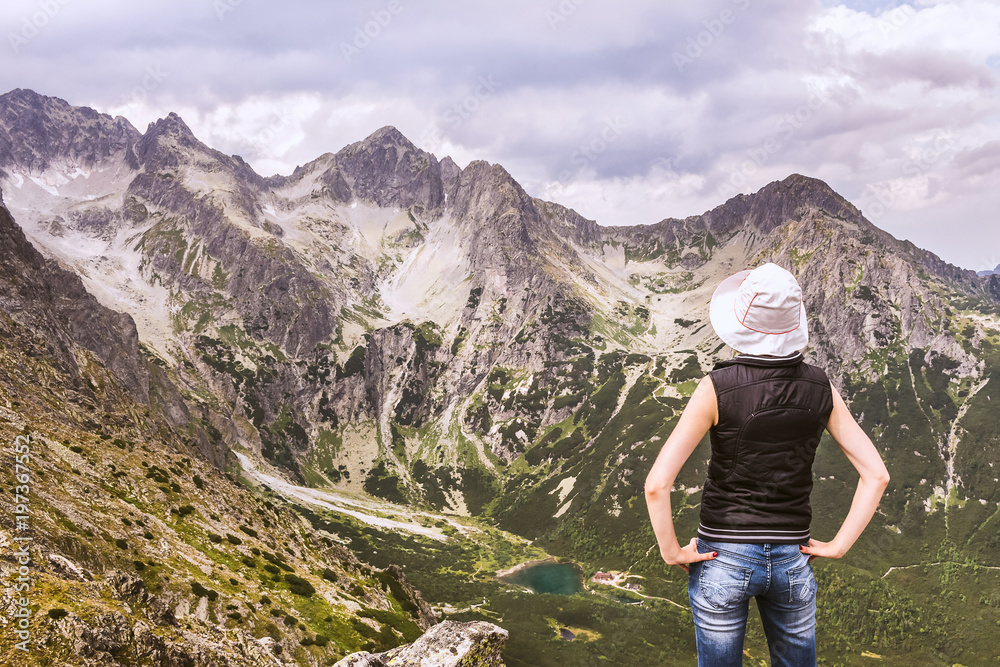 Kobieta na szczycie góry, podziwiająca górskie krajobrazy. Góry Tatry pejzaż ze szczytu.