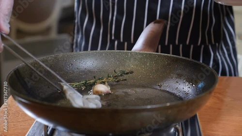 Close-up of a Chef Preparing Flambe Style Dish on a Pan. Slow motion. Oil and Alcohol Ignite with Open Flames. Cooking tiger shrimp. Shot in 4k photo