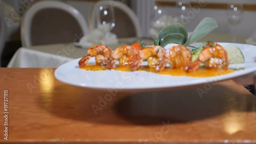 Close-up of Flambe Style Dish of tiger shrimp on a plate being served in restaurant by waiter in gloves. Smoke Slow motion. . Full hd photo
