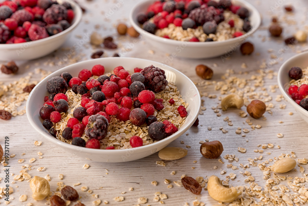 Oatmeal, nuts, woody fruit on a wooden background, ingredients, healthy food