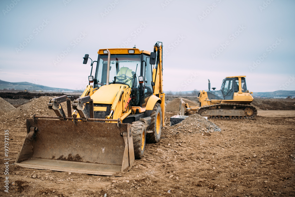 Industrial backhoe excavator loader and bulldozer machinery on construction site Industrial backhoe excavator loader and bulldozer machinery on construction site