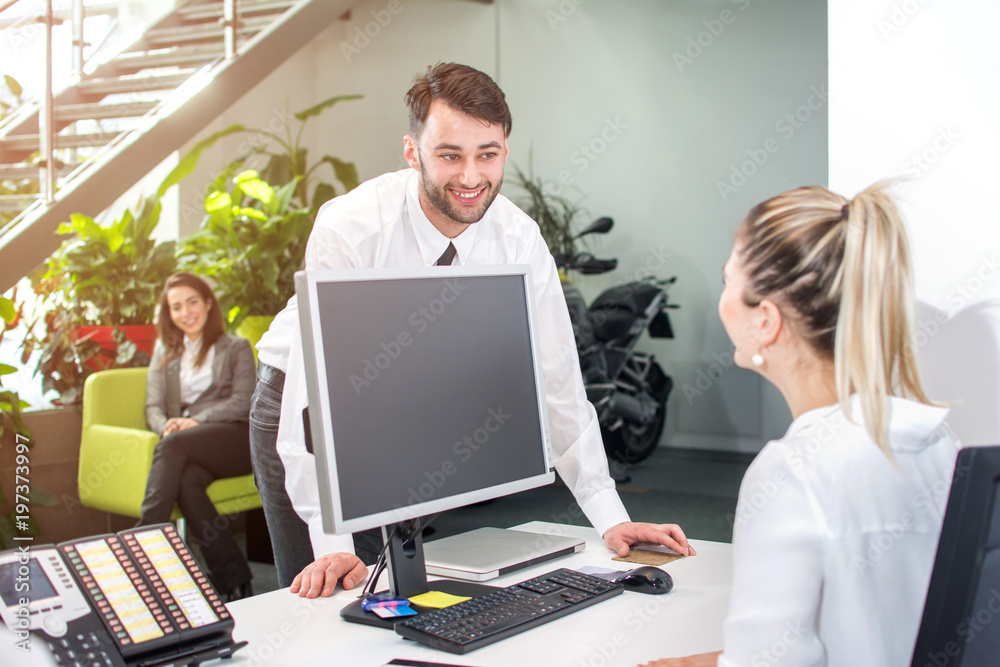 Businessman talking with secretary in office reception area. Businessman talking with secretary in office reception area.
