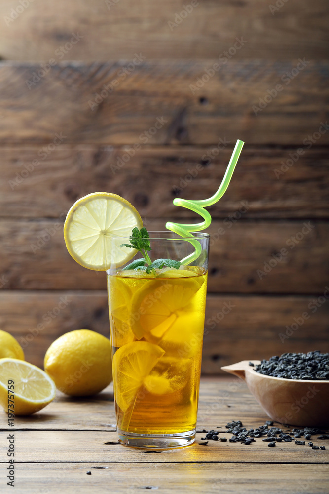 te' ghiacciato con limone bicchiere su sfondo di legno rustico te' ghiacciato con limone bicchiere su sfondo di legno rustico
