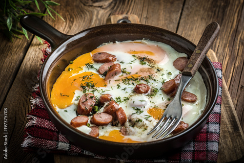 Tasty cooked egg with chopped sausages.