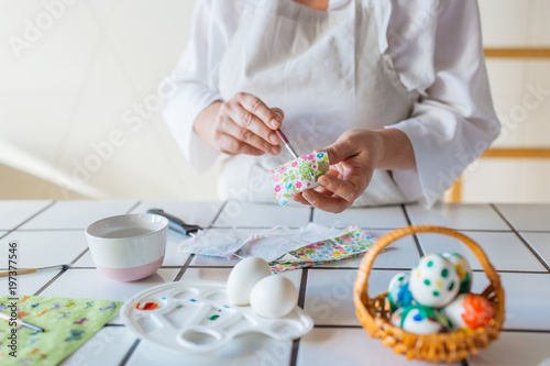 Woman decorating eggs with decoupage technique   photo