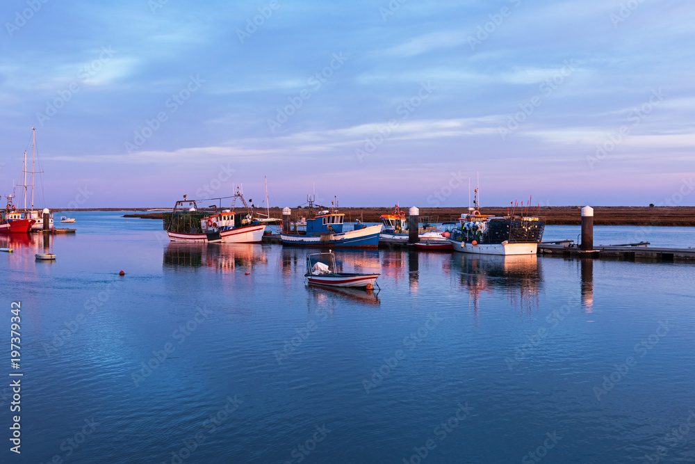 Fishing boats at the pier in Santa Luzia village at sunset, Portugal Fishing boats at the pier in Santa Luzia village at sunset, Portugal