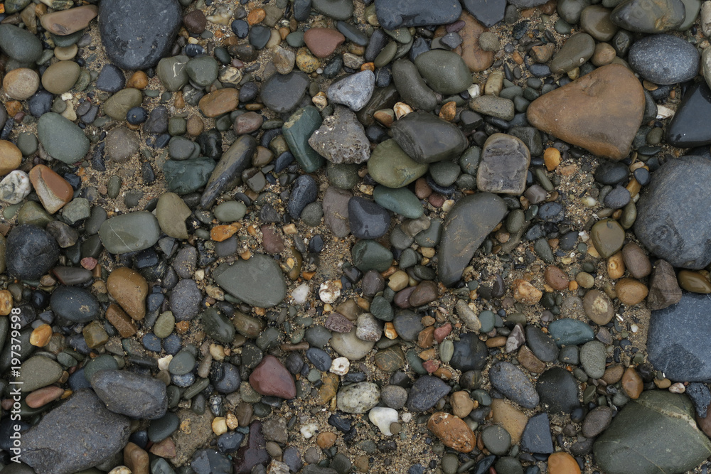 Rocky textures with round stones of different colors and sand aswell as dirt inbetween - beach seaside Rocky textures with round stones of different colors and sand aswell as dirt inbetween - beach seaside