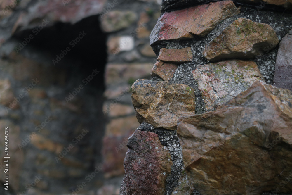 Closeup of antique old stone wall built with imperfect different sized rocks - Abandoned ruins