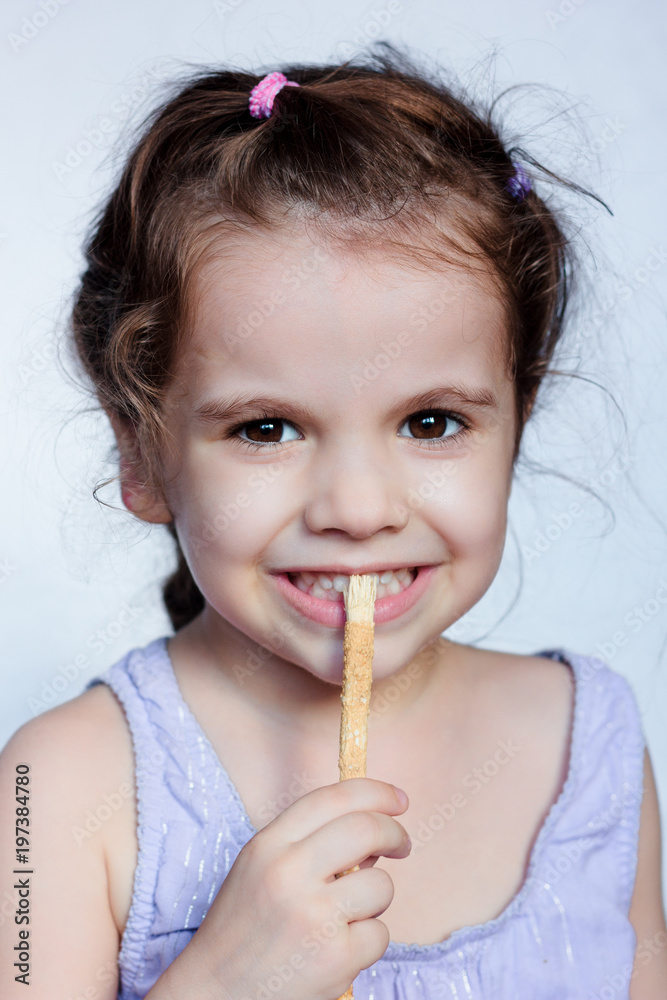 Little kid girl holding miswak in hands and making teeth cleaning procedure. Little kid girl holding miswak in hands and making teeth cleaning procedure.