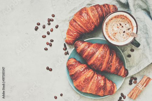 Breakfast, croissants with coffee on a grey background, toned. The view from the top,place for your text.