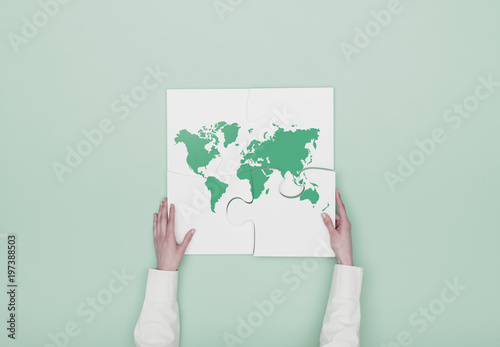 Woman completing a puzzle with a world map