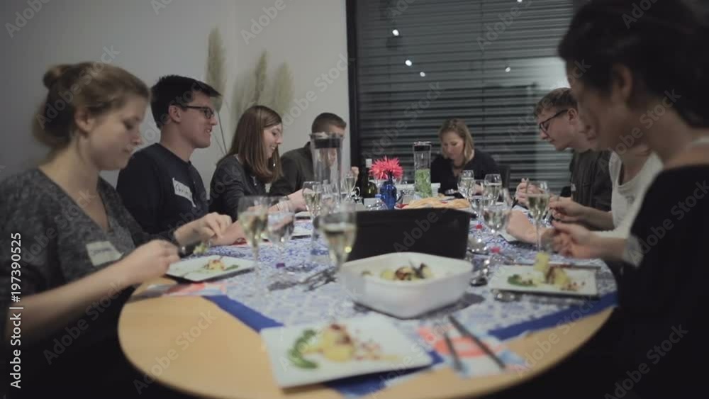 Real life moments: cooking classroom group enjoying dinner and a conversation. Teacher and students interacting. Slow motion. Medium shot. Selective focus. Real life moments: cooking classroom group enjoying dinner and a conversation. Teacher and students interacting. Slow motion. Medium shot. Selective focus.