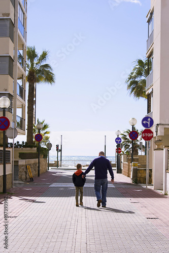 boy with his father walking in the city by the sea Spain Salou in the spring © mikitiger