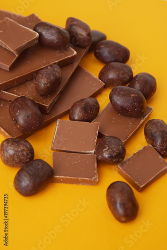 Chocolate Bar and Chocolate Pieces over Yellow Background. Sweet Dessert. top view. photo