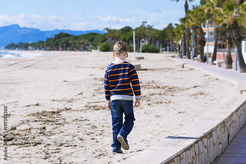 boy walks along the seafront at the seashore Spain in the spring