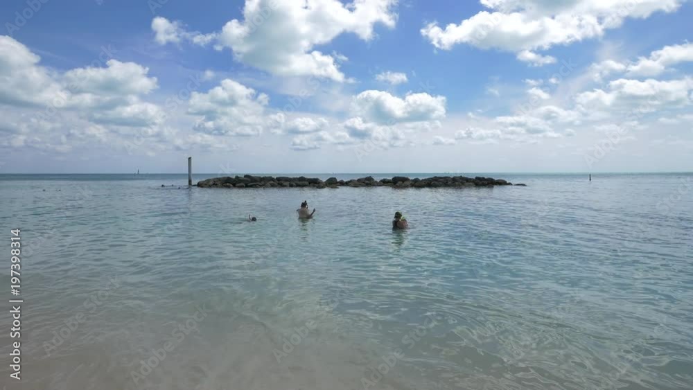 People swimming in the ocean water People swimming in the ocean water