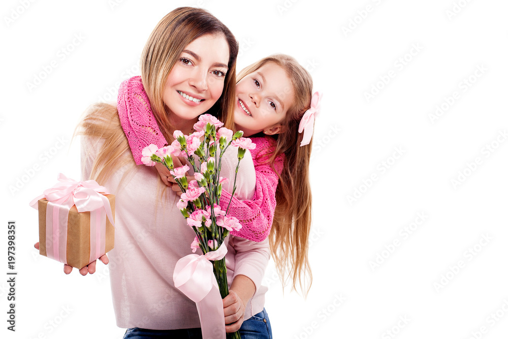 Happy smiling mother and daughter in pink pullovers with gift box and bouquet of carnations isolated on white background. Happy family. Happy mother's day. Happy smiling mother and daughter in pink pullovers with gift box and bouquet of carnations isolated on white background. Happy family. Happy mother's day.