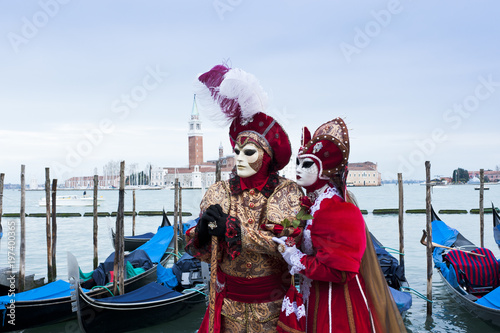Couple of carnival masks in St. Mark's Square in Venice. In the background the church of San Giorgio. Italy © dianacrestan