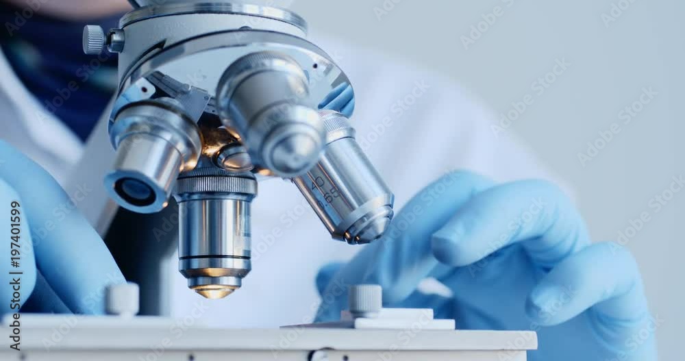 Scientist hands with microscope close-up shot in the laboratory Scientist hands with microscope close-up shot in the laboratory