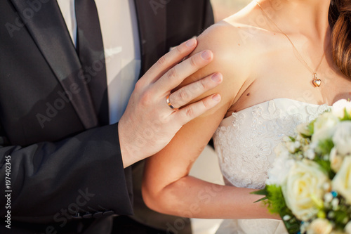 elegant stylish groom gently embracing gorgeous bride. © Mironifamily