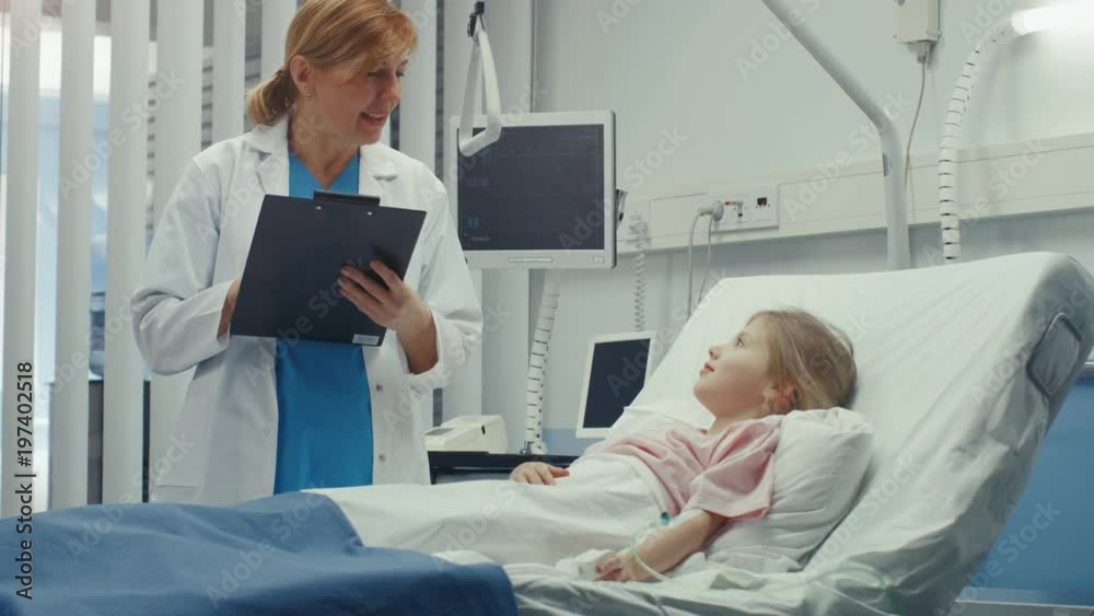 Recovering Little Girl Lies on a Bed In the Hospital, Friendly Doctor With Clipboard Asks Questions.  Shot on RED EPIC-W 8K Helium Cinema Camera.