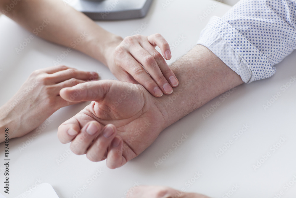 Measuring of pulse on wrist by the doctor.