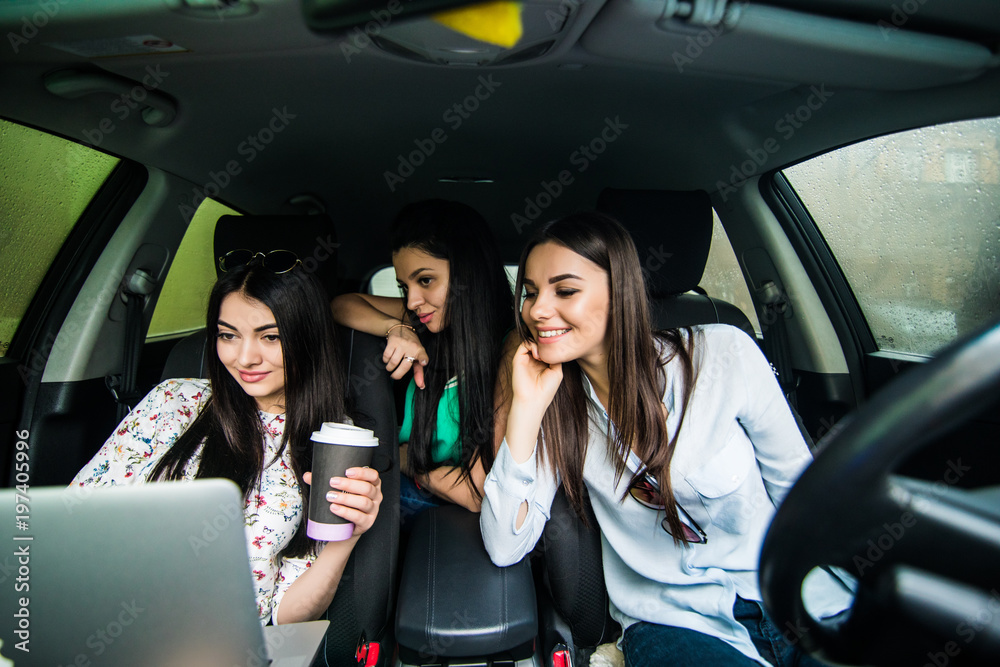 Enjoying their lunch in the car. Three beautiful young cheerful women looking at each other with smile and eating take out food while sitting in car Enjoying their lunch in the car. Three beautiful young cheerful women looking at each other with smile and eating take out food while sitting in car