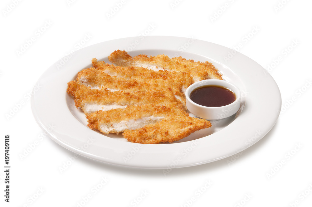 Breaded and fried chicken pieces with sauce in a plate on a white background