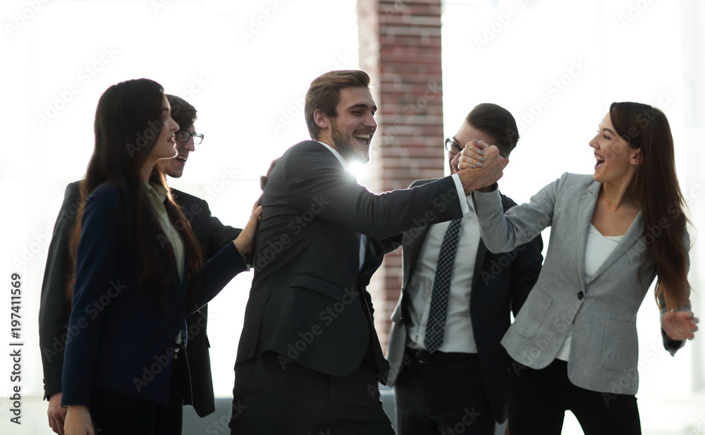 Portrait of an enthusiastic business team congratulating their c