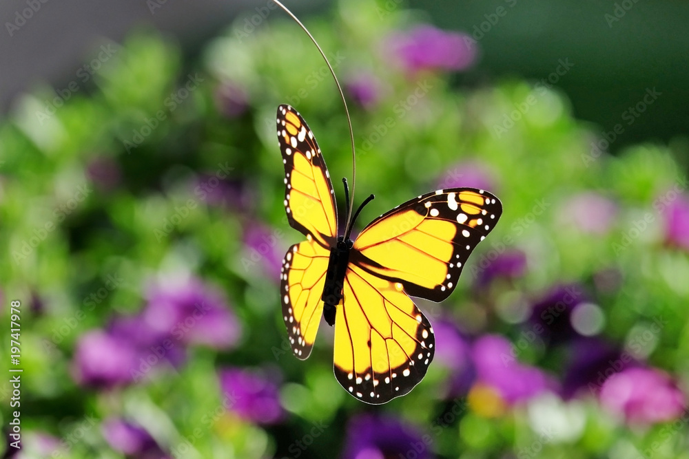 Artificial butterfly on a floral background Artificial butterfly on a floral background
