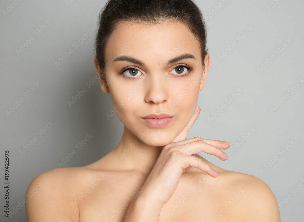 Young woman with beautiful makeup on grey background. Professional cosmetic products Young woman with beautiful makeup on grey background. Professional cosmetic products