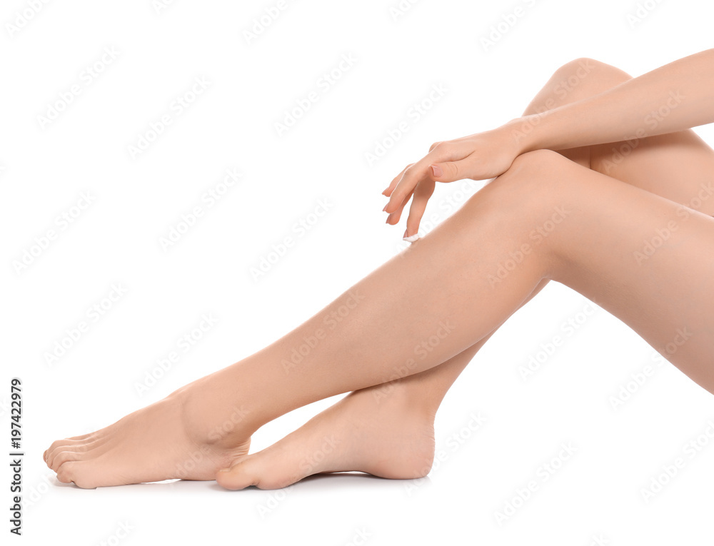 Young woman applying body cream on white background