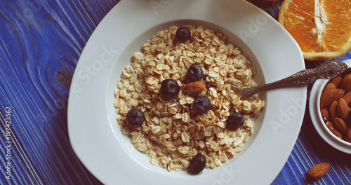 Breakfast with oatmeal and orange juice on blue wooden backgroun