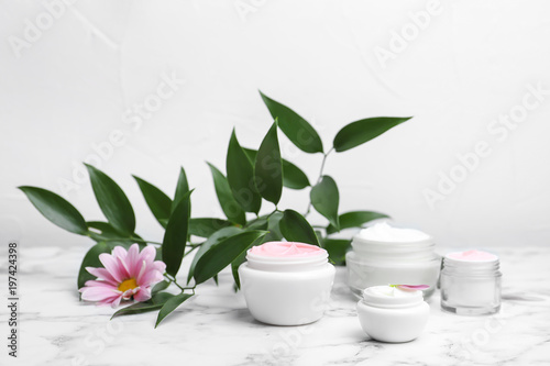 Composition with body cream in jars on light background