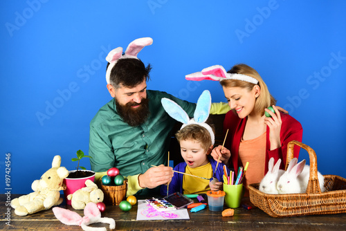 Egg surprise toys. Mother, father and kid painting Easter eggs.