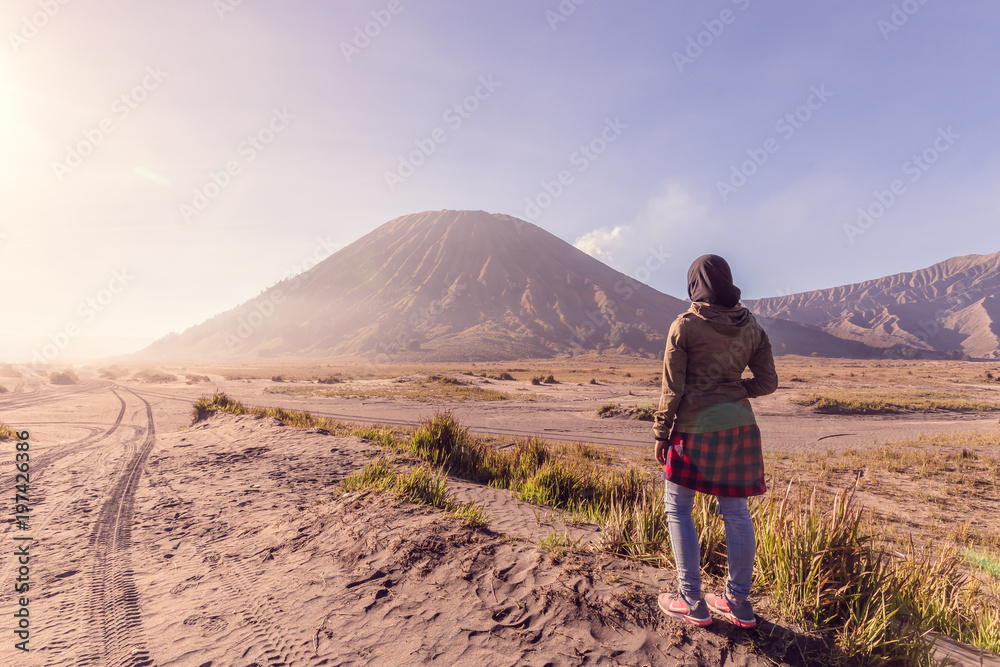 A teenager pose with Bromo mountain as background at East Java Indonesia
