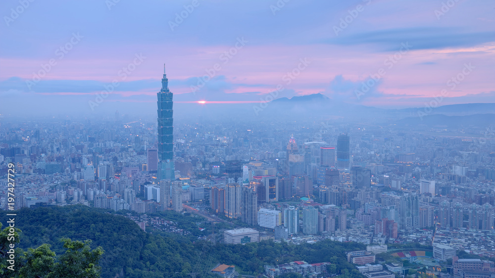 Aerial panorama of busy Taipei City at moody dusk with Taipei 101 in XinYi commercial area, Tamsui River and downtown area in twilight with beautiful rosy afterglow shining through heavy clouds 