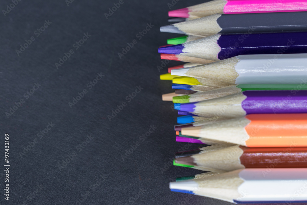 Fototapeta premium Color pencils of different colors lie on a gray background