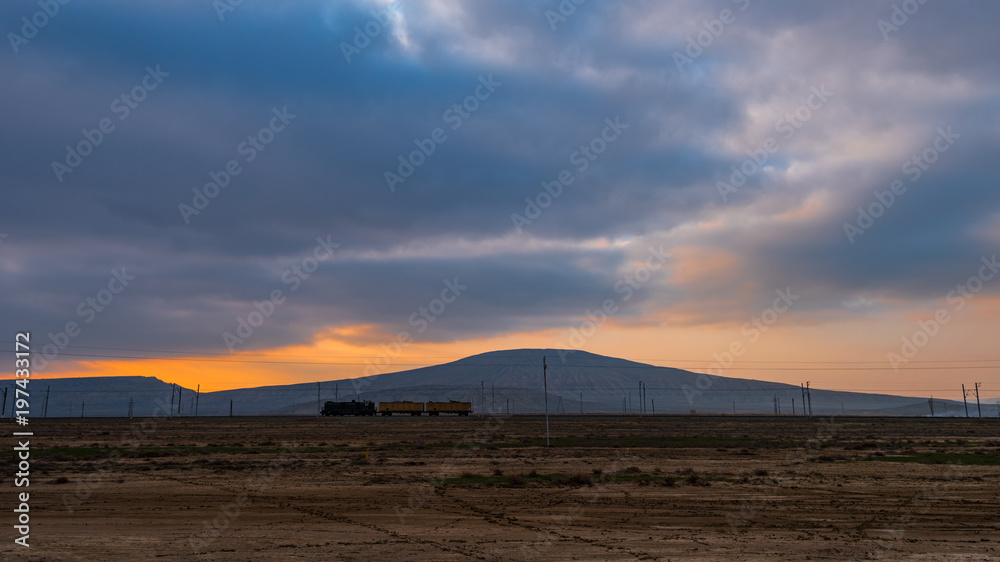 Landscape with a mud volcano at sunset